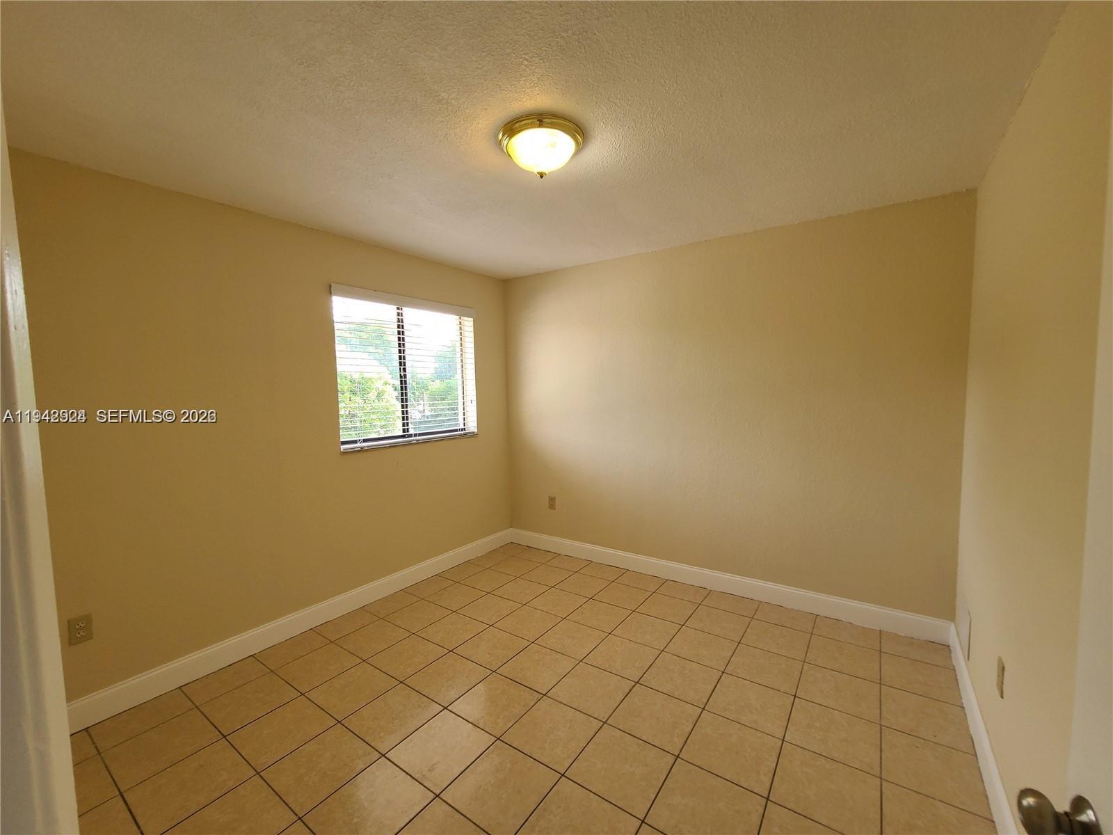 2710 West 60th Place, Unit 202 Hialeah, FL 33016 - Photo 7 of 11 an empty room with windows