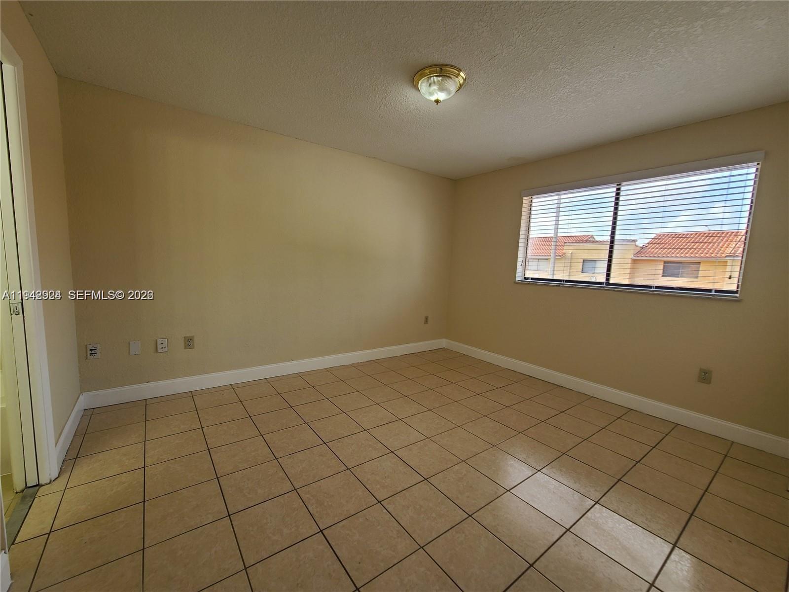 2710 West 60th Place, Unit 202 Hialeah, FL 33016 - Photo 8 of 11 an empty room with windows
