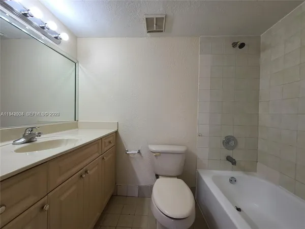 a bathroom with a granite countertop toilet a sink and a bathtub