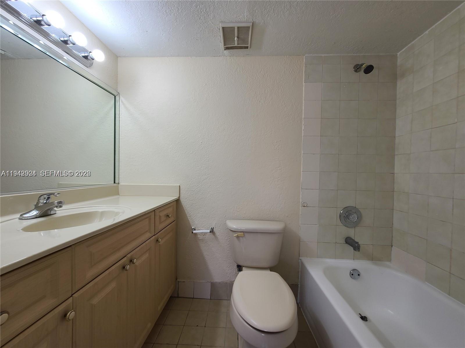 2710 West 60th Place, Unit 202 Hialeah, FL 33016 - Photo 10 of 11 a bathroom with a granite countertop toilet a sink and a bathtub