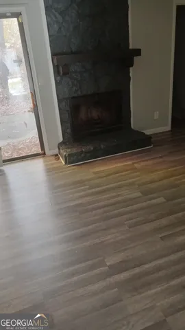 a living room with wooden floor and a fireplace