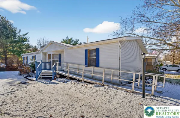 a view of a house with a yard and wooden fence
