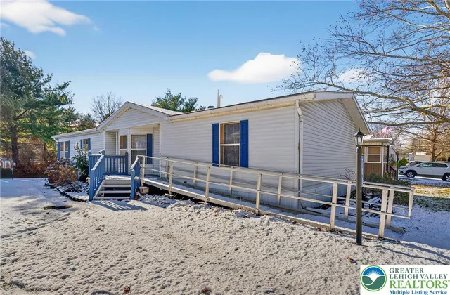 a view of a house with a yard and wooden fence