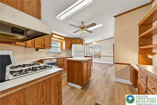 a kitchen with stainless steel appliances a stove a sink dishwasher and a refrigerator with wooden floor