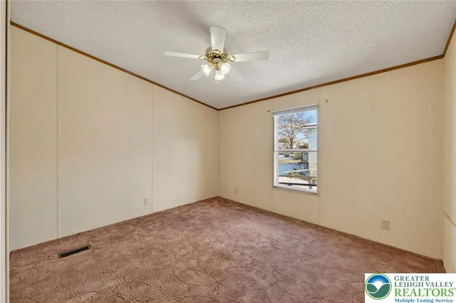 an empty room with windows and chandelier fan