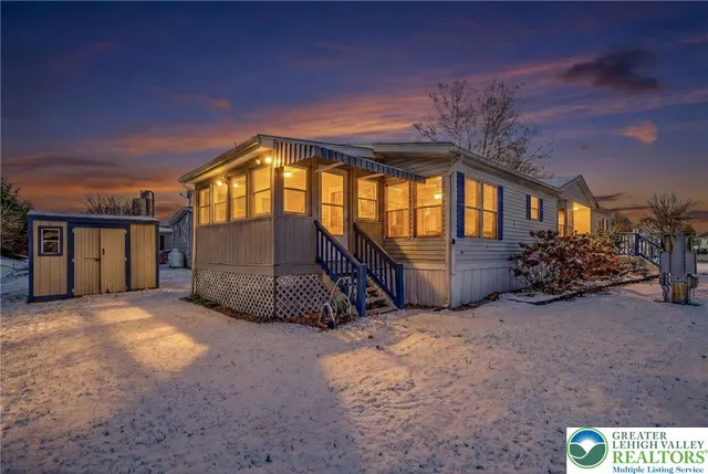 a view of a house with a big yard and large tree