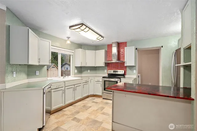 a kitchen with stainless steel appliances granite countertop a sink stove refrigerator and cabinets