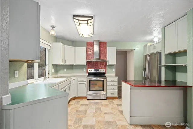 a kitchen with stainless steel appliances granite countertop a refrigerator and a stove top oven
