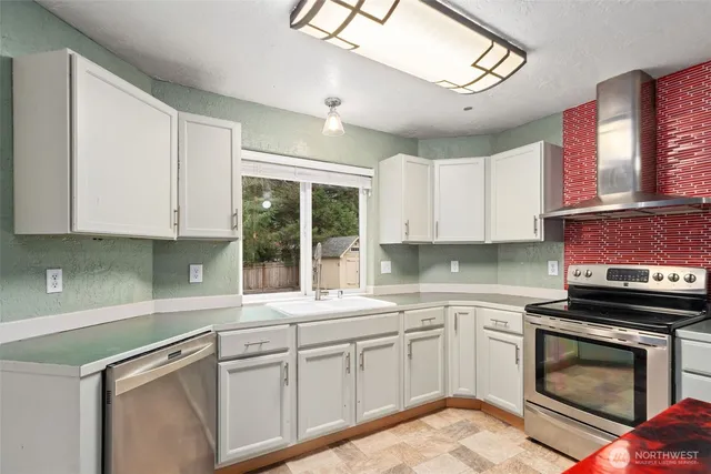 a kitchen with cabinets appliances a sink and a window