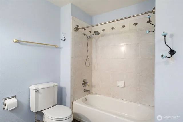 a white toilet sitting next to a bath tub