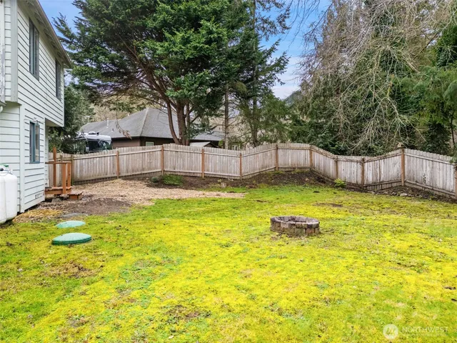 a view of a backyard with table and chairs and wooden fence