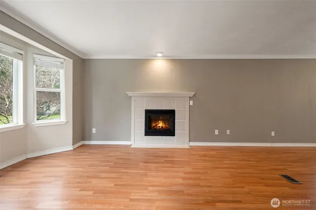 a view of an empty room with window and fire place