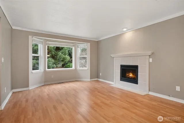 a view of empty room with wooden floor and fireplace