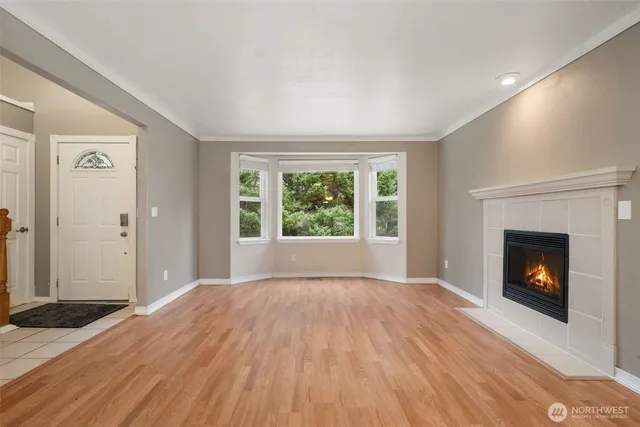 a view of empty room with wooden floor and fireplace