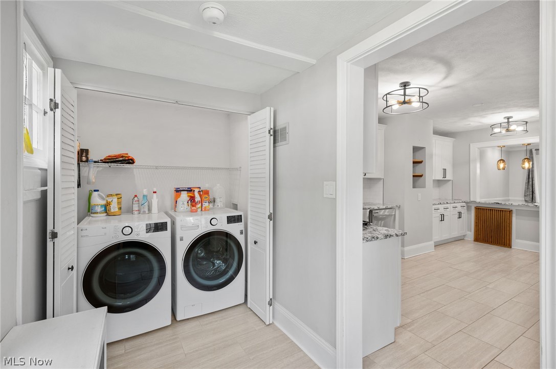 2924 Brighton Road Shaker Heights, OH 44120 - Photo 7 of 31 Laundry room with independent washer and dryer, a chandelier, and baseboards