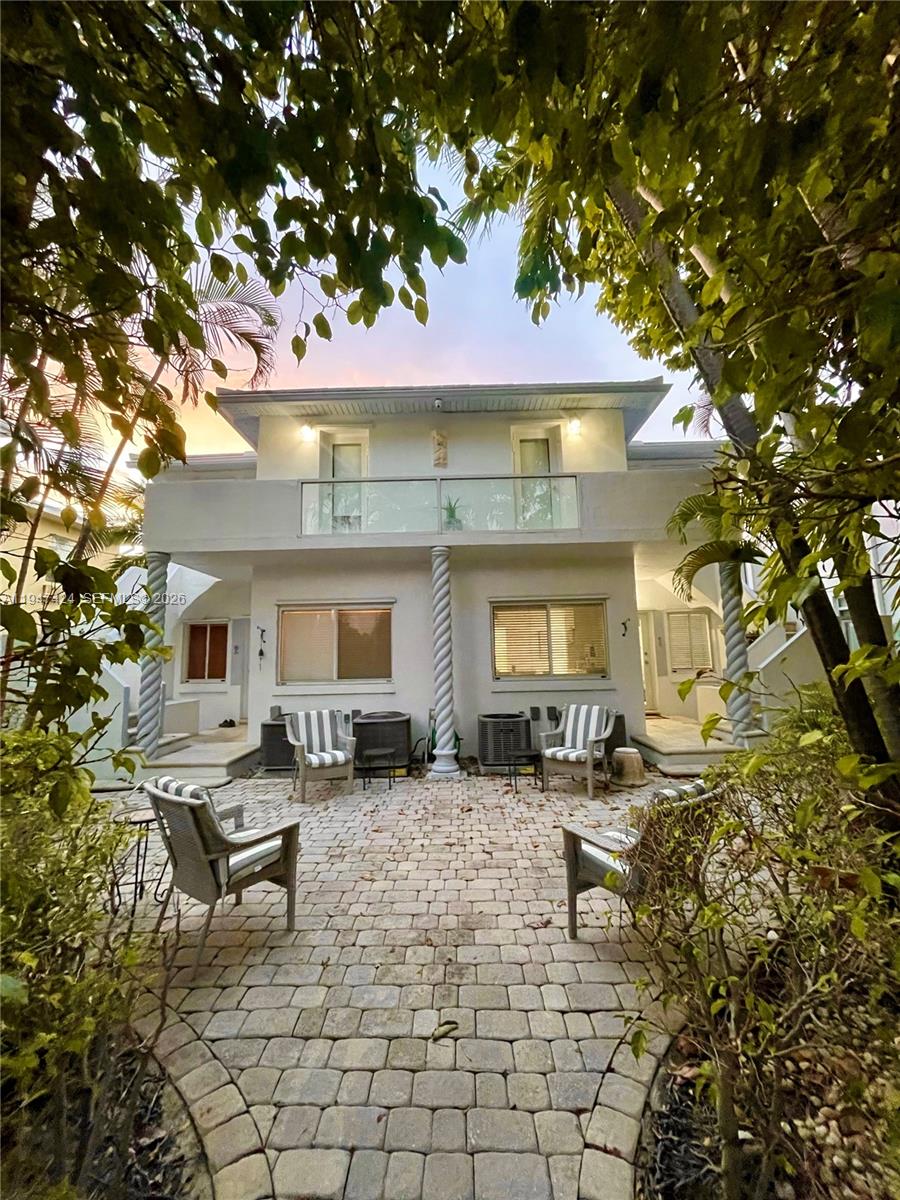 a front view of a house with large trees