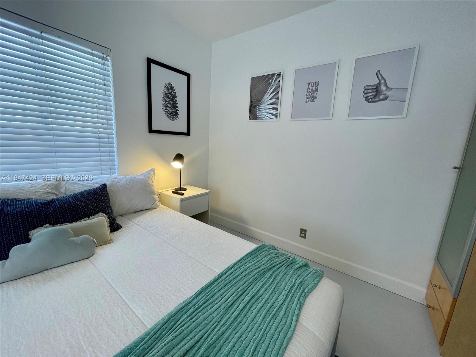 8036 Harding Avenue, Unit 1 Miami Beach, FL 33141 - Photo 13 of 33 a bedroom with a bed and wall painting