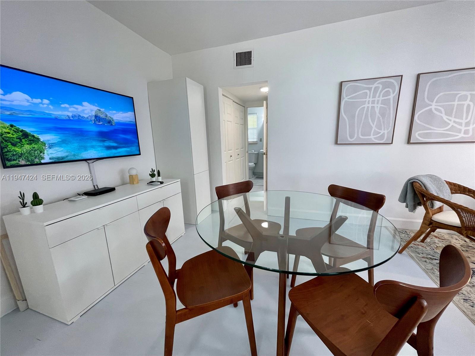 8036 Harding Avenue, Unit 1 Miami Beach, FL 33141 - Photo 19 of 33 a view of a dining room with furniture and wooden floor
