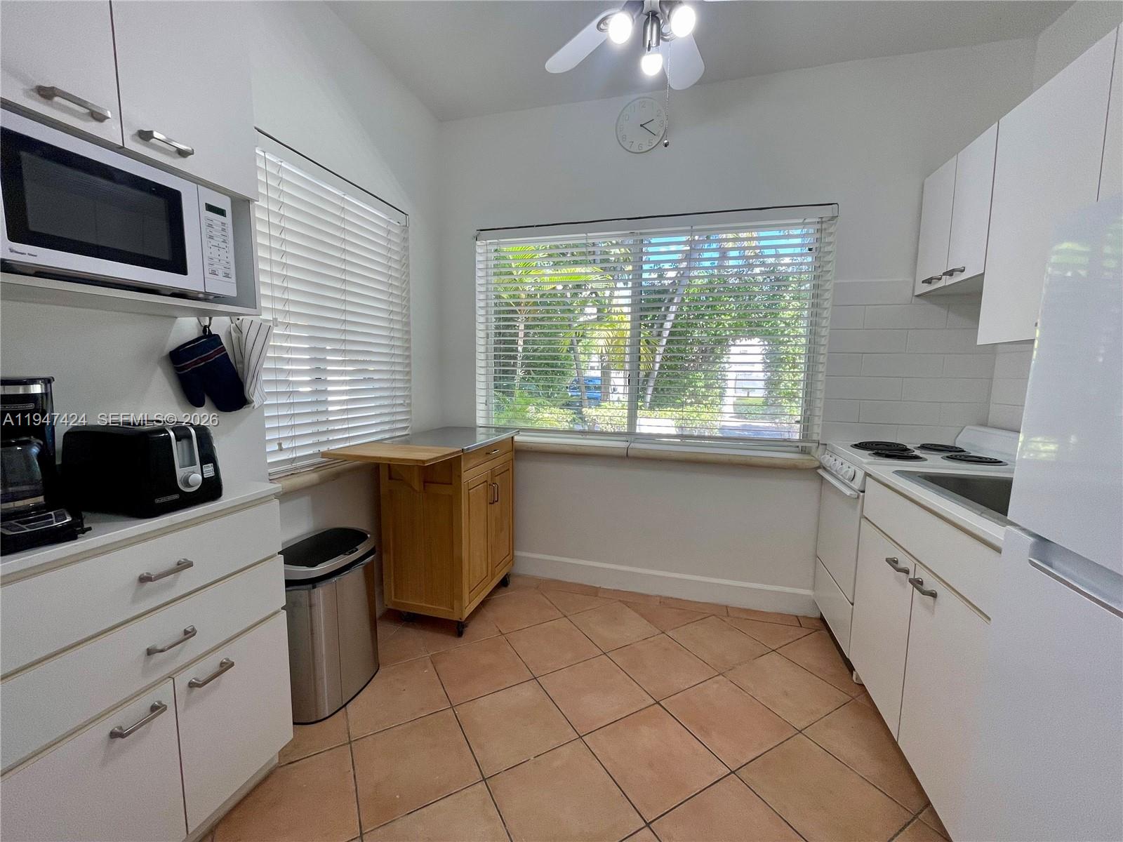 8036 Harding Avenue, Unit 1 Miami Beach, FL 33141 - Photo 20 of 33 a kitchen with a stove a sink and a microwave