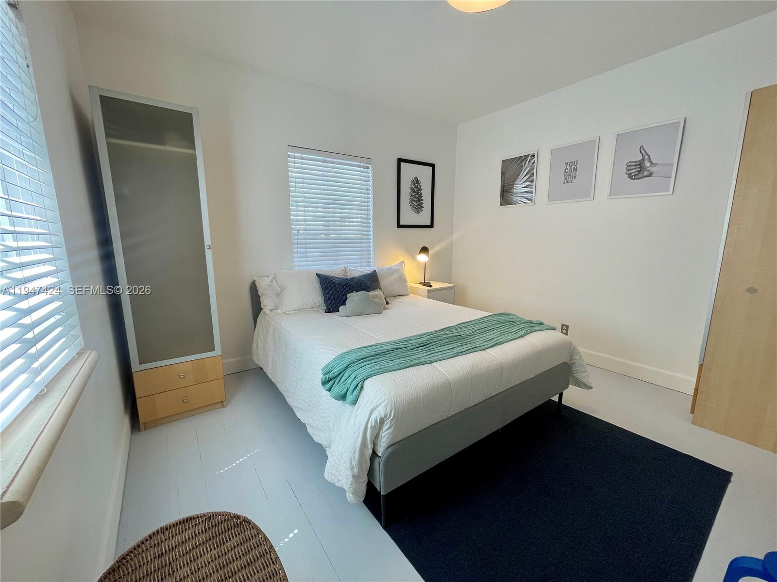 8036 Harding Avenue, Unit 1 Miami Beach, FL 33141 - Photo 27 of 33 a bedroom with a bed and wooden floor