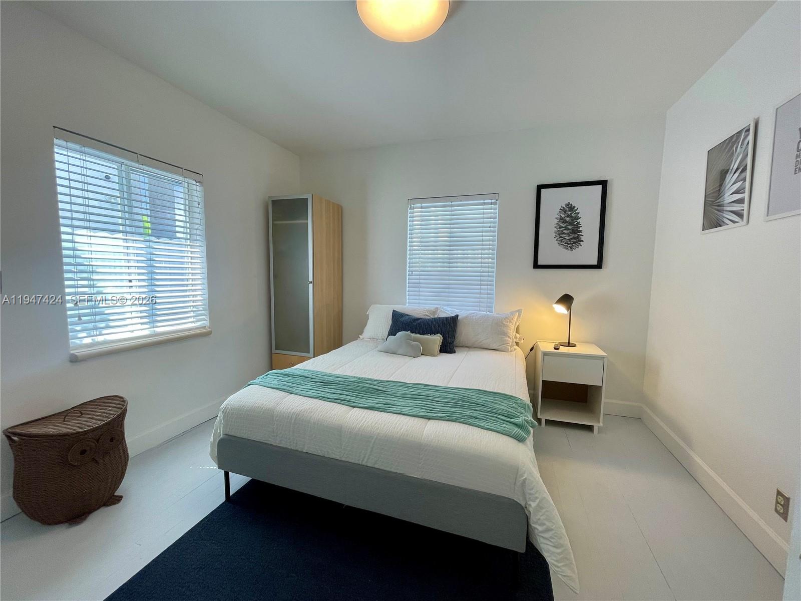 8036 Harding Avenue, Unit 1 Miami Beach, FL 33141 - Photo 28 of 33 a bedroom with a bed and a lamp