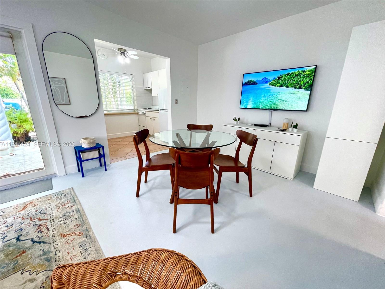 8036 Harding Avenue, Unit 1 Miami Beach, FL 33141 - Photo 3 of 33 a living room with furniture a mirror and a flat screen tv