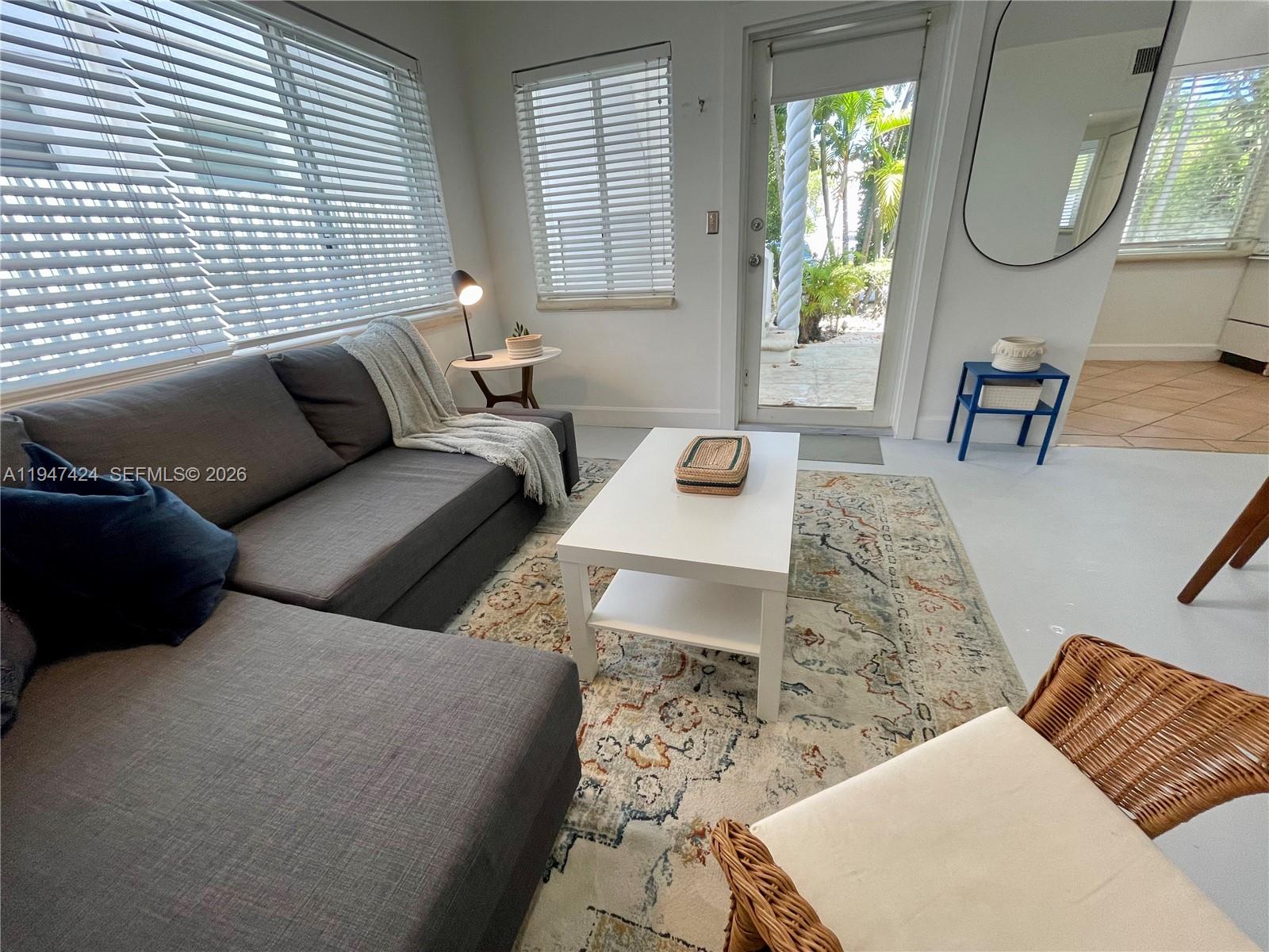 8036 Harding Avenue, Unit 1 Miami Beach, FL 33141 - Photo 5 of 33 a living room with furniture rug a lamp and a large window