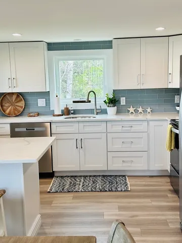 a kitchen with a table chairs refrigerator and window