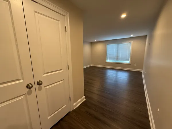 an empty room with wooden floor and a window