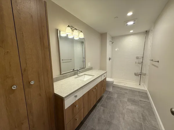 a bathroom with a double vanity sink mirror and a bathtub