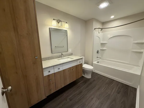 a bathroom with a double vanity sink toilet mirror and shower