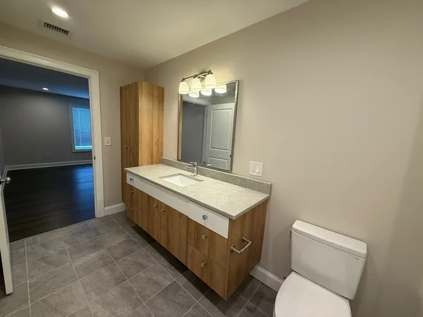 a bathroom with a sink a toilet and mirror