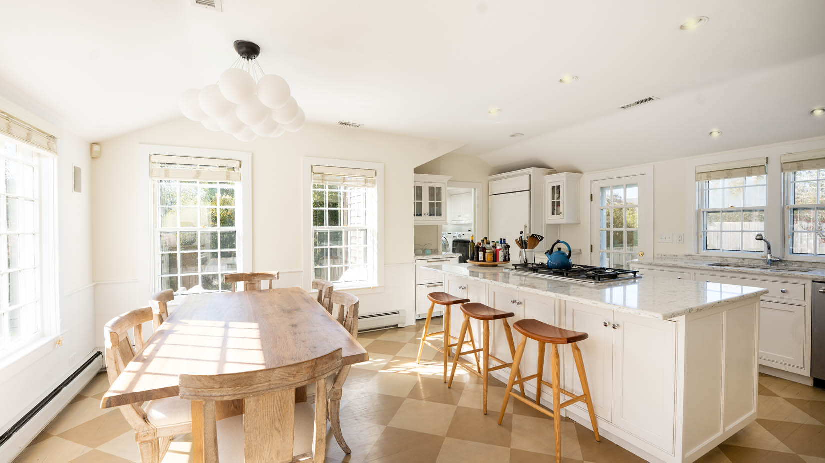 60 Cliff Road Nantucket, MA 02554 - Photo 13 of 54 a large kitchen with kitchen island granite countertop a stove a sink a dining table and chairs