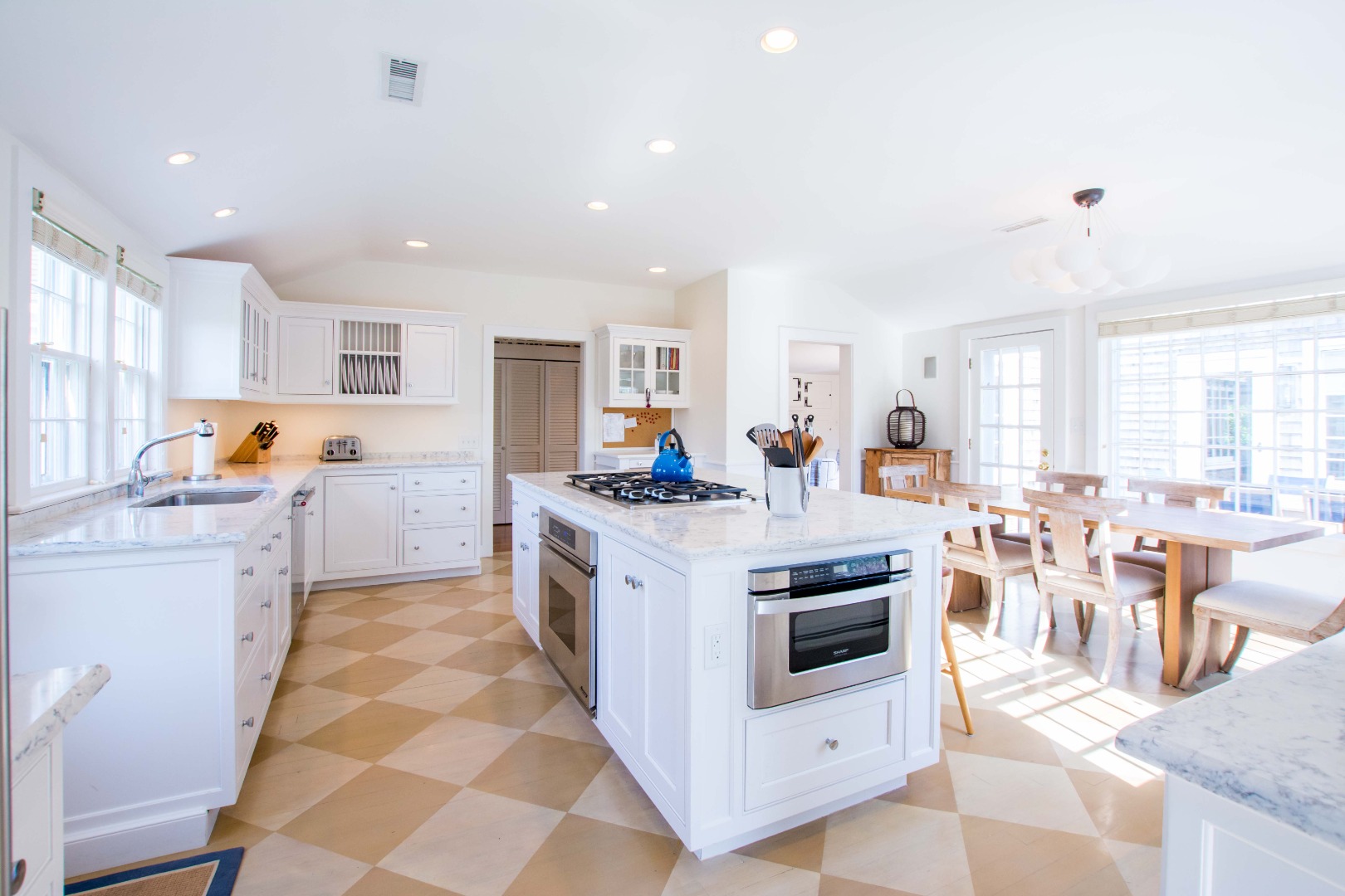 60 Cliff Road Nantucket, MA 02554 - Photo 15 of 54 a kitchen with stainless steel appliances granite countertop a stove a sink a dining table and chairs