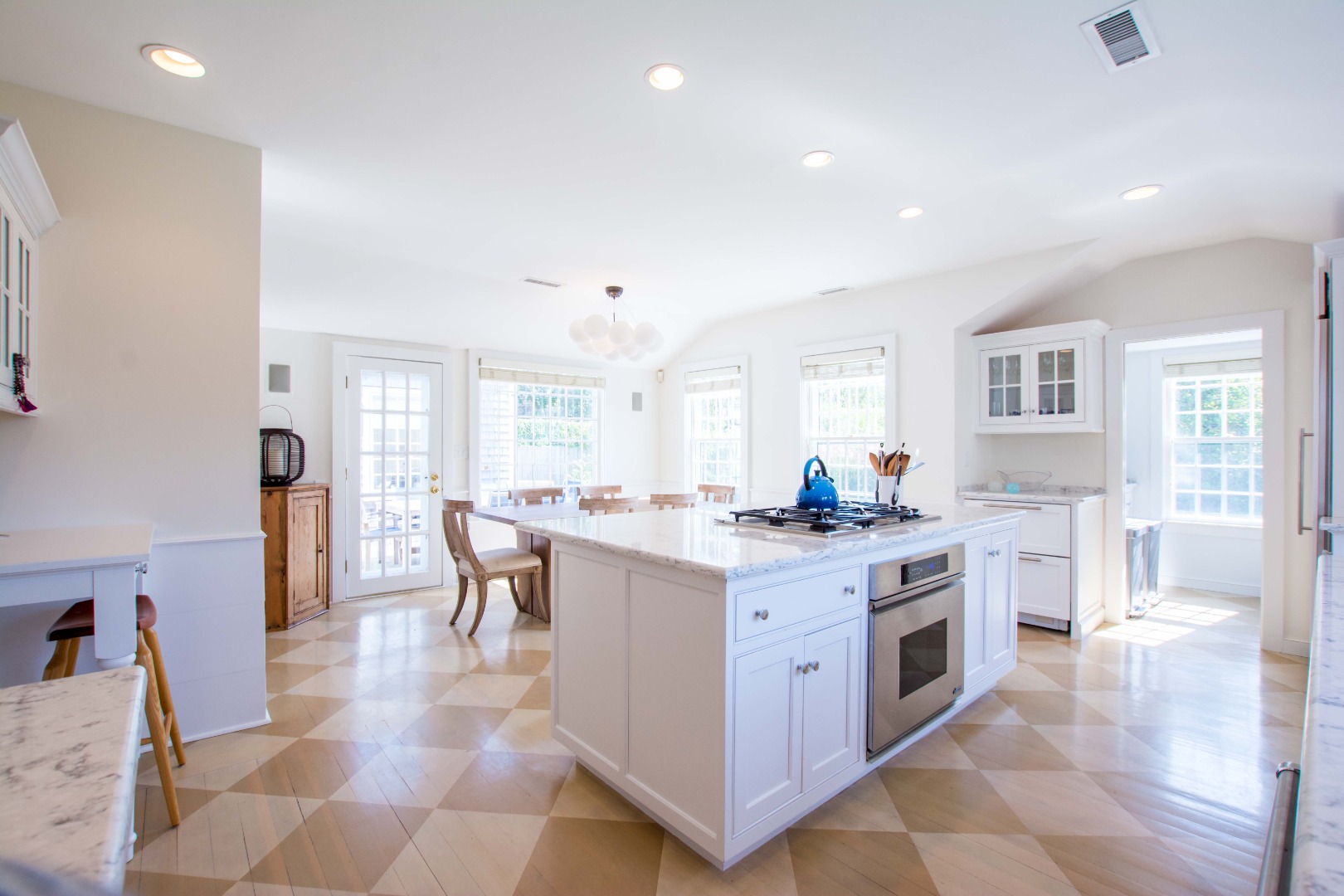 60 Cliff Road Nantucket, MA 02554 - Photo 16 of 54 a kitchen with a stove a sink a dining table and chairs