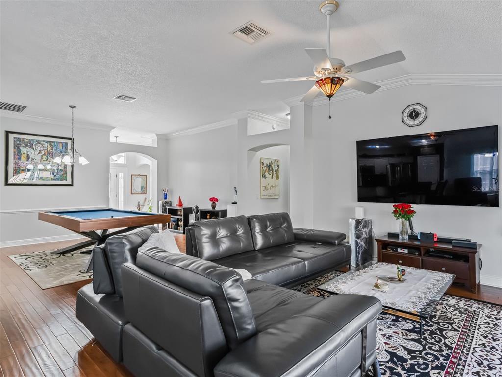 1085 Ridgeland Path The Villages, FL 32162 - Photo 15 of 56 a living room with furniture a flat screen tv and kitchen view
