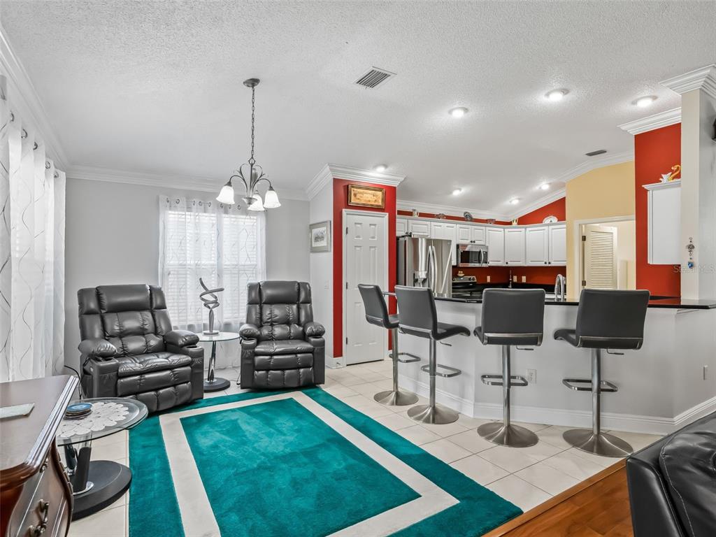 1085 Ridgeland Path The Villages, FL 32162 - Photo 17 of 56 a living room with lots of furniture and kitchen view