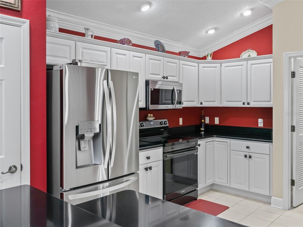 1085 Ridgeland Path The Villages, FL 32162 - Photo 19 of 56 a kitchen with stainless steel appliances a stove a refrigerator and cabinets