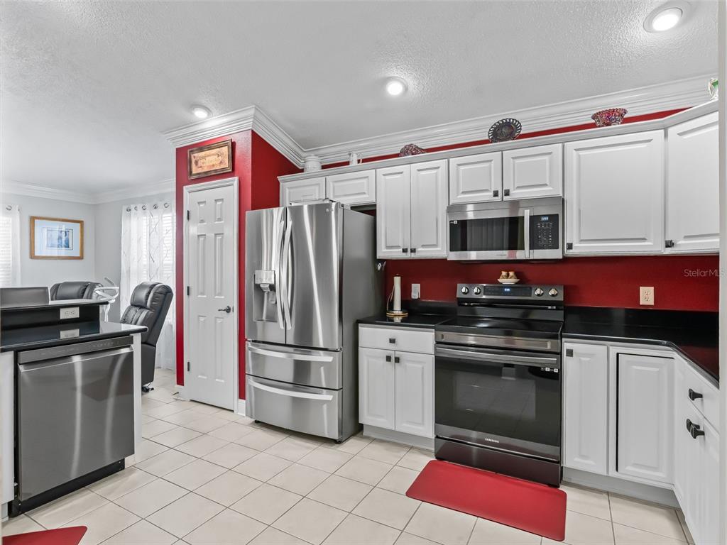 1085 Ridgeland Path The Villages, FL 32162 - Photo 21 of 56 a kitchen with stainless steel appliances granite countertop a stove refrigerator and microwave