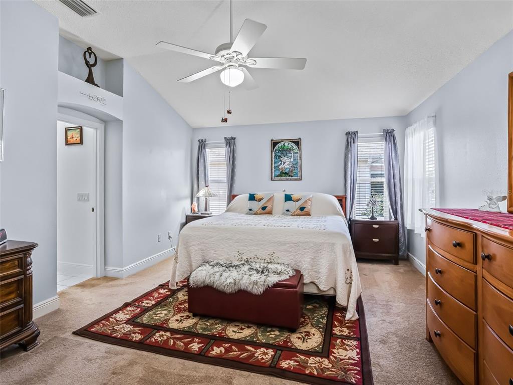 1085 Ridgeland Path The Villages, FL 32162 - Photo 28 of 56 a bedroom with a large bed and a chandelier