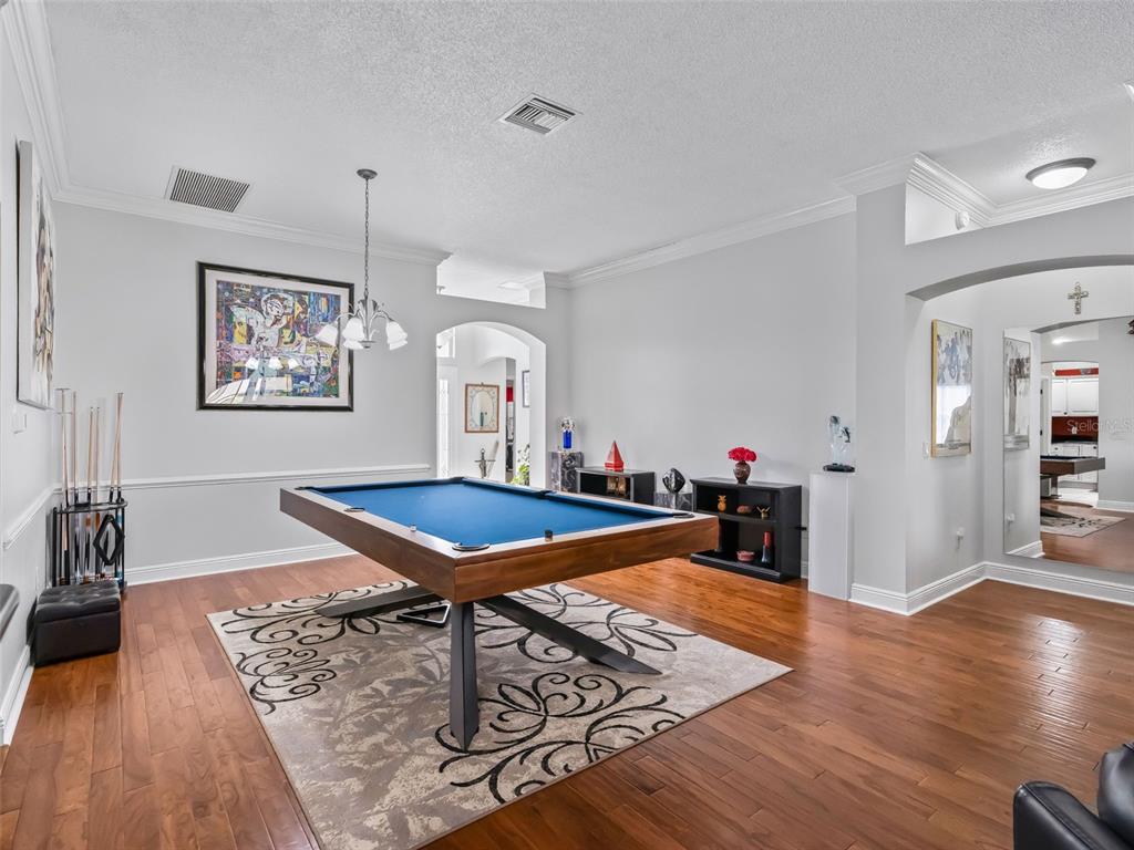 1085 Ridgeland Path The Villages, FL 32162 - Photo 9 of 56 a living room with furniture pool table and wooden floor