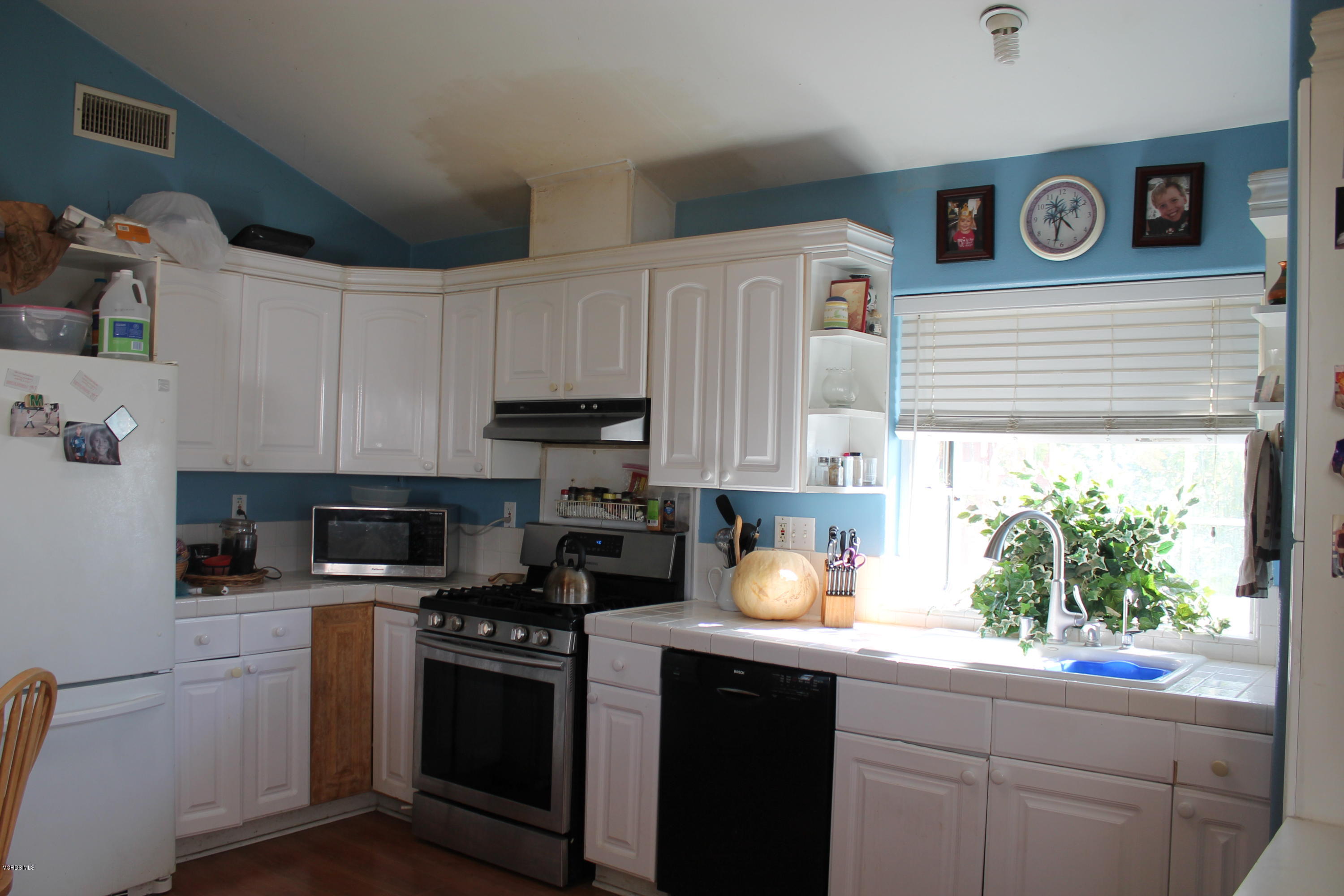 838 East Stroube Street Oxnard, CA 93036 - Photo 8 of 13 a kitchen with stainless steel appliances a stove a sink and a refrigerator