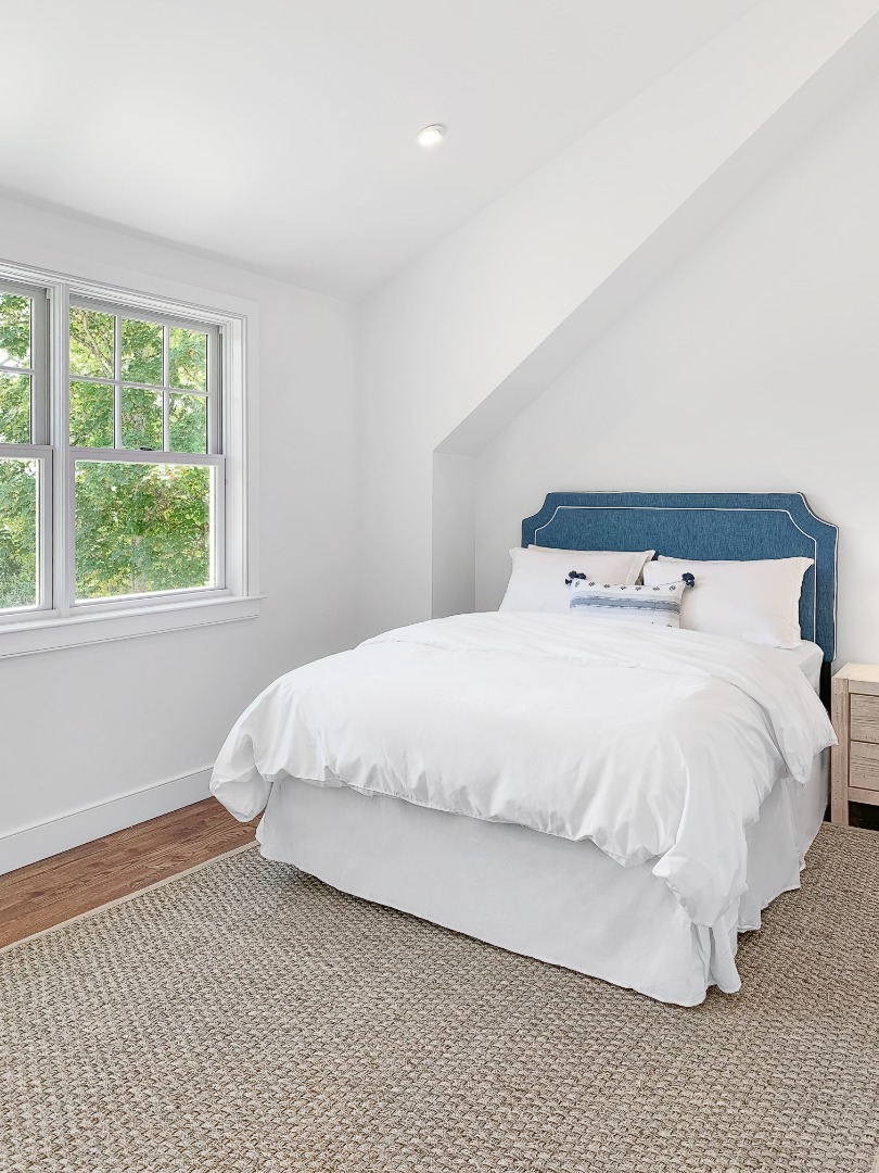 70 Curtis Lane Edgartown, MA 02539 - Photo 26 of 34 a large bed sitting in a bedroom next to a window