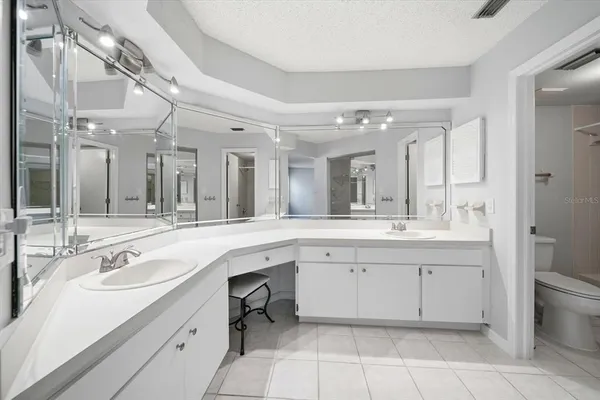 a spacious bathroom with a granite countertop sink a toilet and a mirror