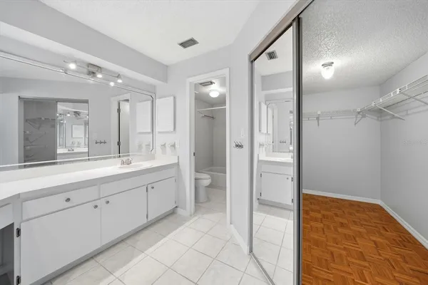 a spacious bathroom with a mirror sink and shower