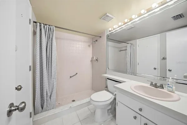 a bathroom with a granite countertop sink toilet a shower a mirror and shower