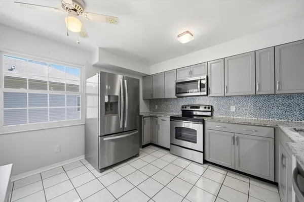 a kitchen with stainless steel appliances granite countertop a refrigerator and a stove top oven