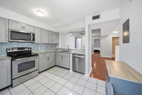a kitchen with granite countertop cabinets stainless steel appliances and a counter space
