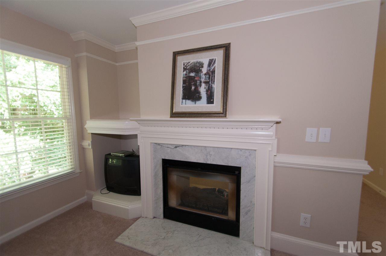 8905 Braceridge Road Raleigh, NC 27613 - Photo 12 of 25 a living room with a fireplace and a window