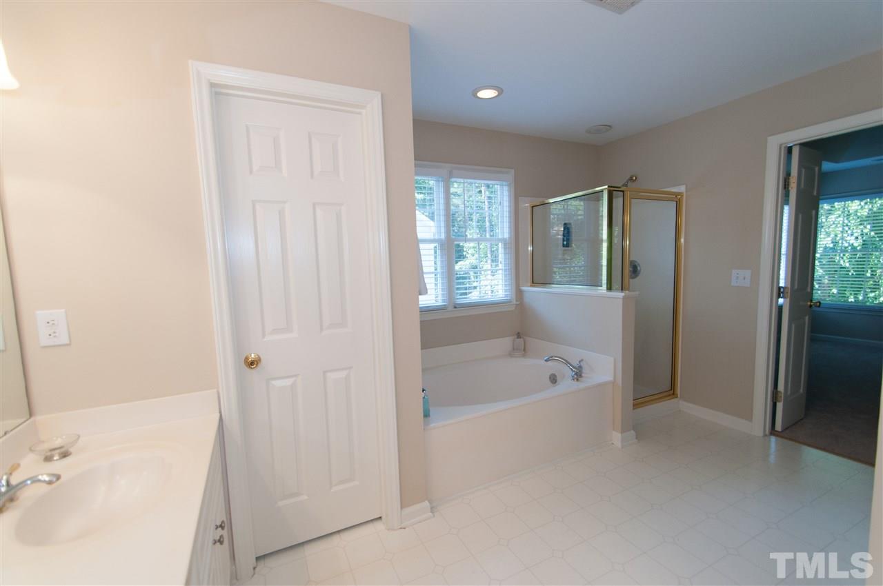 8905 Braceridge Road Raleigh, NC 27613 - Photo 14 of 25 a bathroom with a tub shower and sink